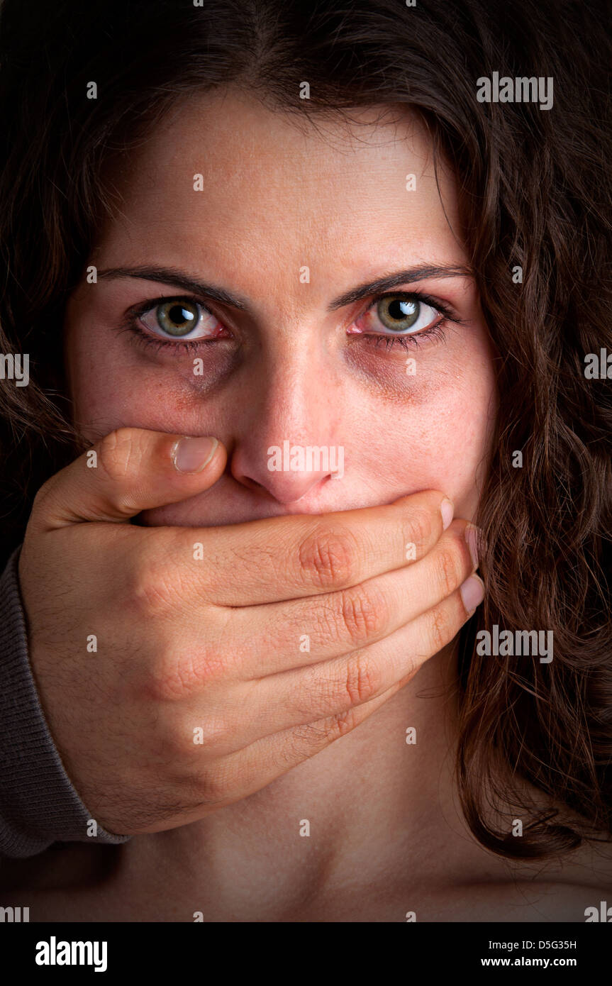 Nahaufnahme von einem mans Hand den Mund zu einem Womans. Konzept von häuslicher Gewalt oder Entführung. Düstere Stimmung. Stockfoto