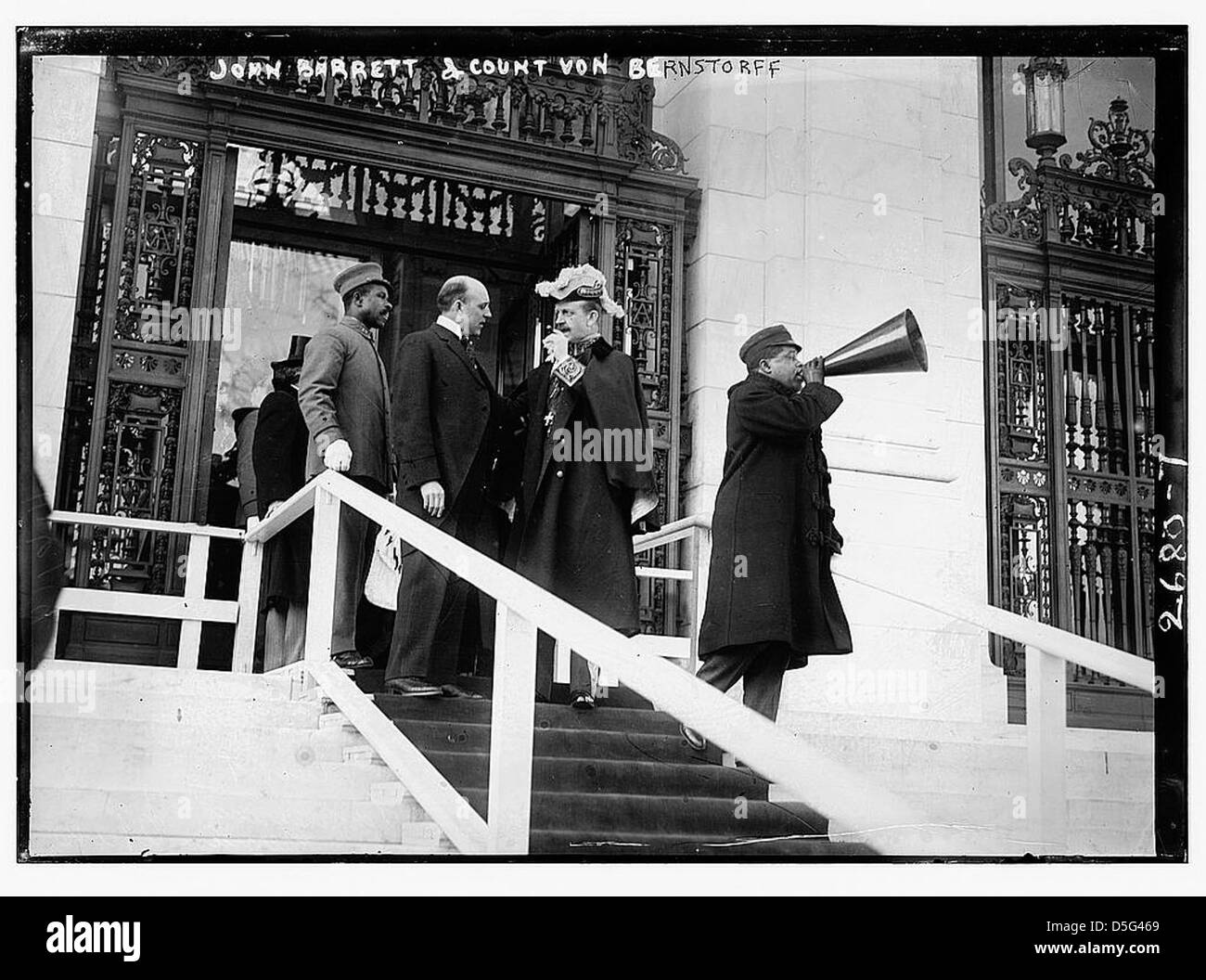 John Barrett und Graf von Bernstorff werden in einer historischen Umgebung auf einer Treppe mit Teppichboden in der Nähe des Pan American Union Building abgebildet. Das Foto repräsentiert einen Moment der internationalen Diplomatie. Stockfoto
