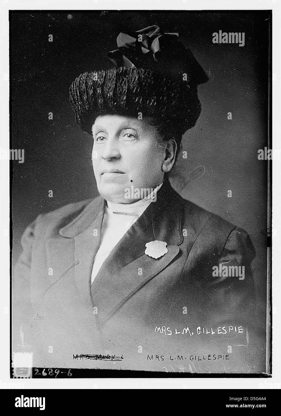 Mrs. L. M. Gillespie, eine bemerkenswerte Figur in der Polizeiarbeit, wird in einem formellen Porträt fotografiert. Sie trägt einen Anzug, ein Polizeiabzeichen und einen Hut, was ihre Beiträge zur Strafverfolgung als Frau im Feld symbolisiert. Stockfoto