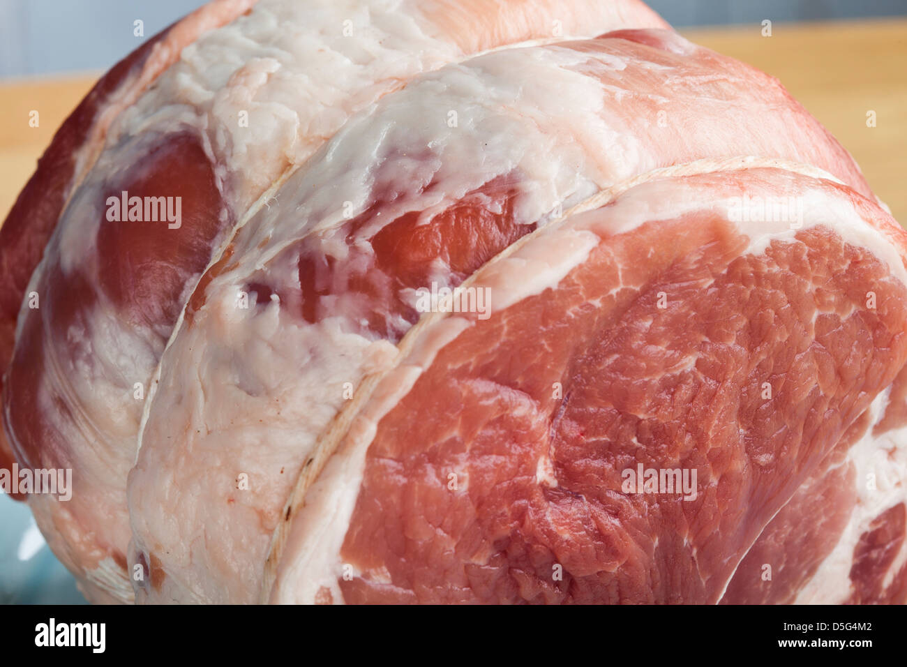 2,5 Pfund rohes Schweinefleisch braten auf einem blauen Teller Stockfoto