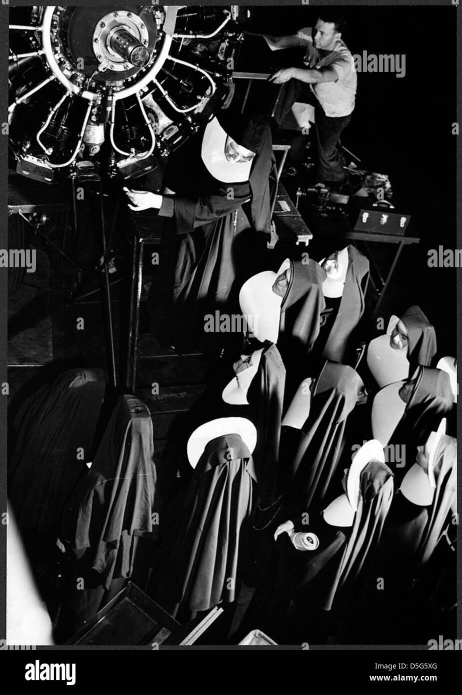 Schwester Aquinas, eine Nonne, die an einer Vorflugklasse beteiligt war, wird ihren Schülern während einer Exkursion zum Washington National Airport im Juni 1943 gezeigt, wie sie die Triebwerksstruktur erklärt. Das Foto zeigt die Rolle der Frauen in der Luftfahrtausbildung während des Zweiten Weltkriegs Stockfoto