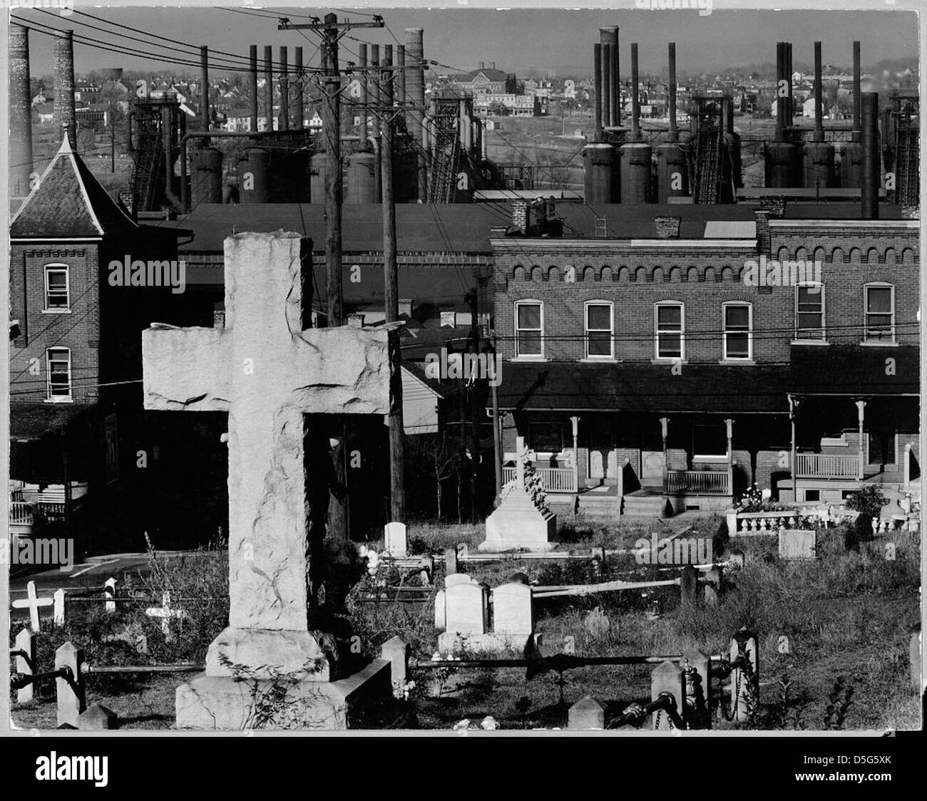 Eine Fotografie von Walker Evans, die 1935 einen Friedhof in der Nähe einer Stahlfabrik in Bethlehem, Pennsylvania, darstellt. Das Bild stellt die Heiligkeit des Friedhofs mit der industriellen Kulisse in Kontrast und symbolisiert den Niedergang der Stahlindustrie. Stockfoto