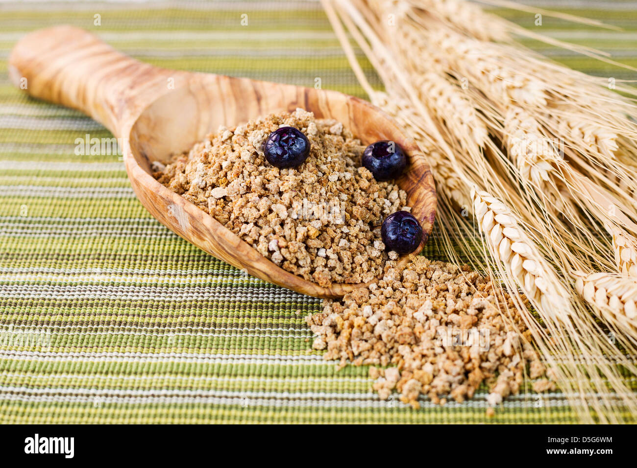 Natürliche Getreide in Holzlöffel mit weißen Stielen Stockfoto