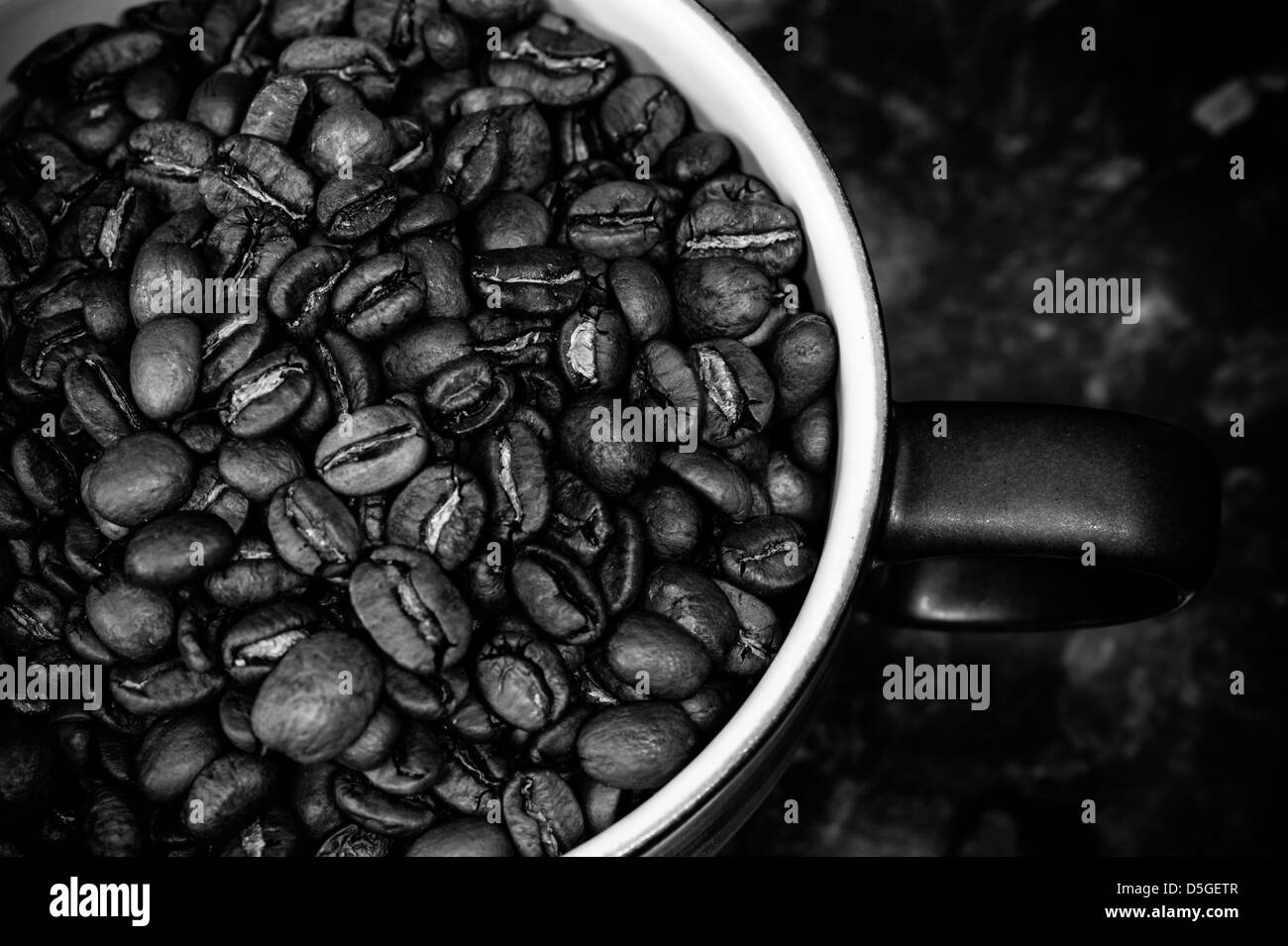 Rösten von Kaffeebohnen in einer kleinen behandelt Tasse in schwarz / weiß Stockfoto