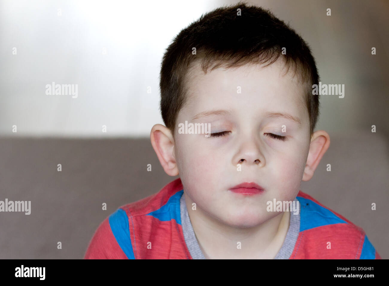 kleiner Junge mit seinen Augen fest geschlossen Stockfoto