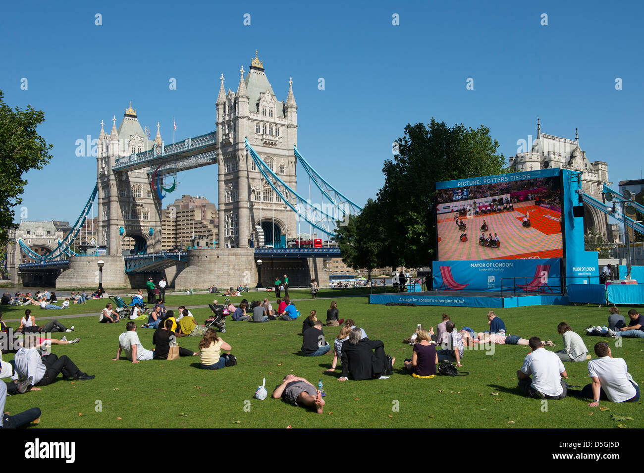 Menschenmassen beobachten die Olympischen Spiele in London 2012 auf einem großen Bildschirm von Tower Bridge, London, England. Stockfoto