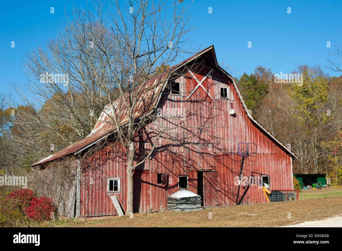 Eine alte rote verwitterte Scheune steht Bronzedarstellung auf einer klaren Herbstmorgen. Stockfoto