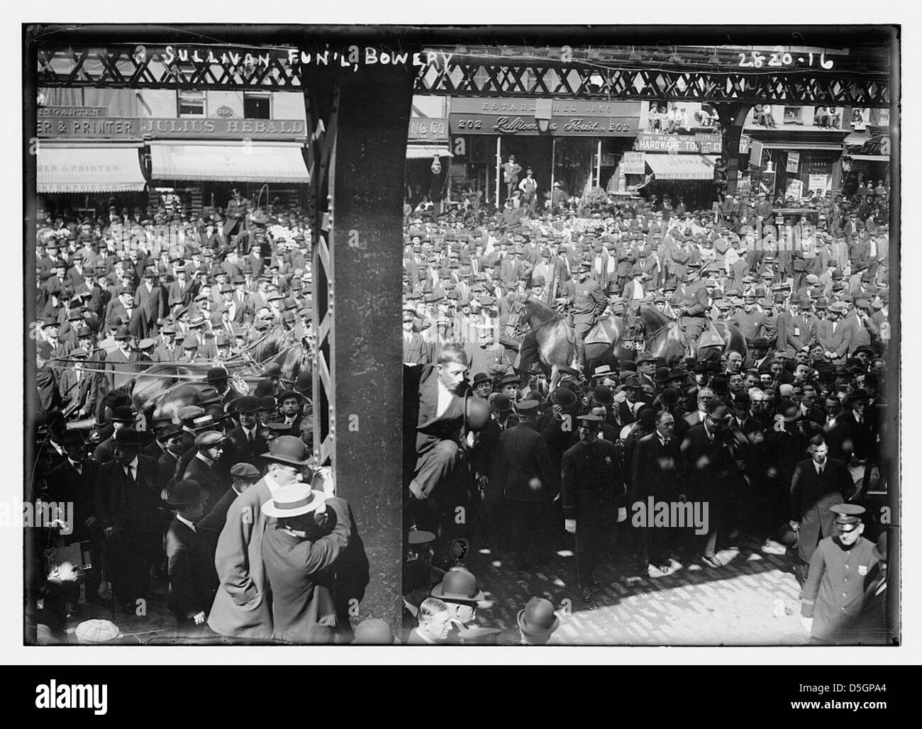 Die Beerdigung von Tim Sullivan, einer politischen Persönlichkeit im New Yorker Stadtteil Bowery, 1913 markiert einen bedeutenden Moment in der Ära der politischen Maschinen. Sullivan, ein Parteiführer der Demokratischen Partei und Mitglied der Tammany Hall, war in Maschinenpolitik involviert. Die Trauerprozession, die in der Nähe des Comanche Clubs stattfand, wurde von berittenen Polizisten und einer großen Menschenmenge begleitet, was den Einfluss Sullivans auf die politische und kriminelle Landschaft von New York veranschaulicht. Stockfoto
