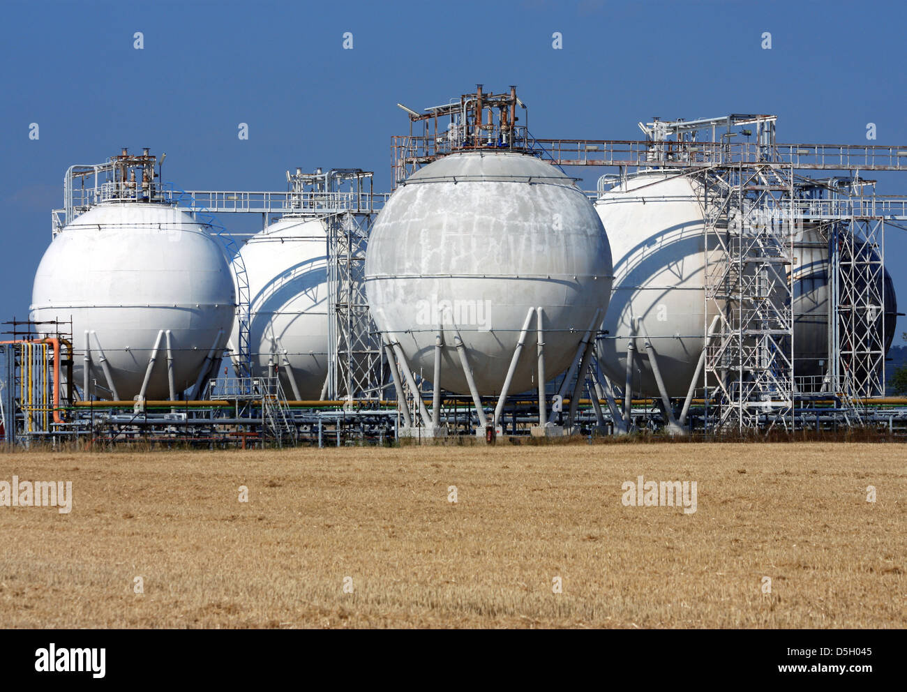 weiße Runde Öltanks und Landwirtschaft Feld Stockfoto