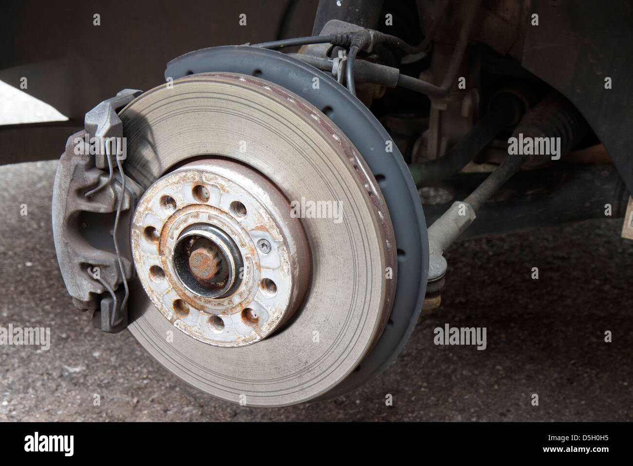 Vorne belüftete Scheibenbremse und Bremssattel auf ein Volkswagen Golf Mark 6 GT.  Die Disc wird getragen. Stockfoto