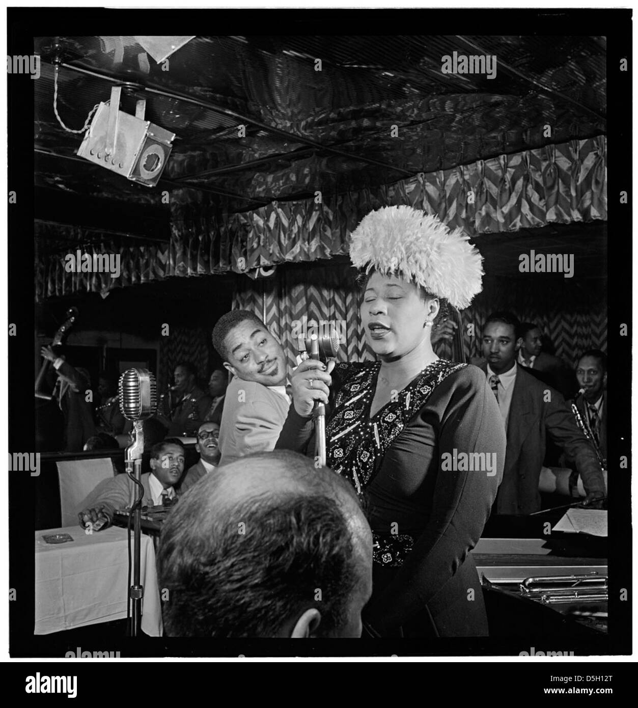 Dieses Foto von 1947 zeigt die Jazzlegenden Ella Fitzgerald, Dizzy Gillespie, Ray Brown, Milt Jackson und Timmie Rosenkrantz. in einem Moment in Downbeat, New York. Dieses historische Bild spiegelt ihren bedeutenden Beitrag zum Jazzgenre wider. Stockfoto