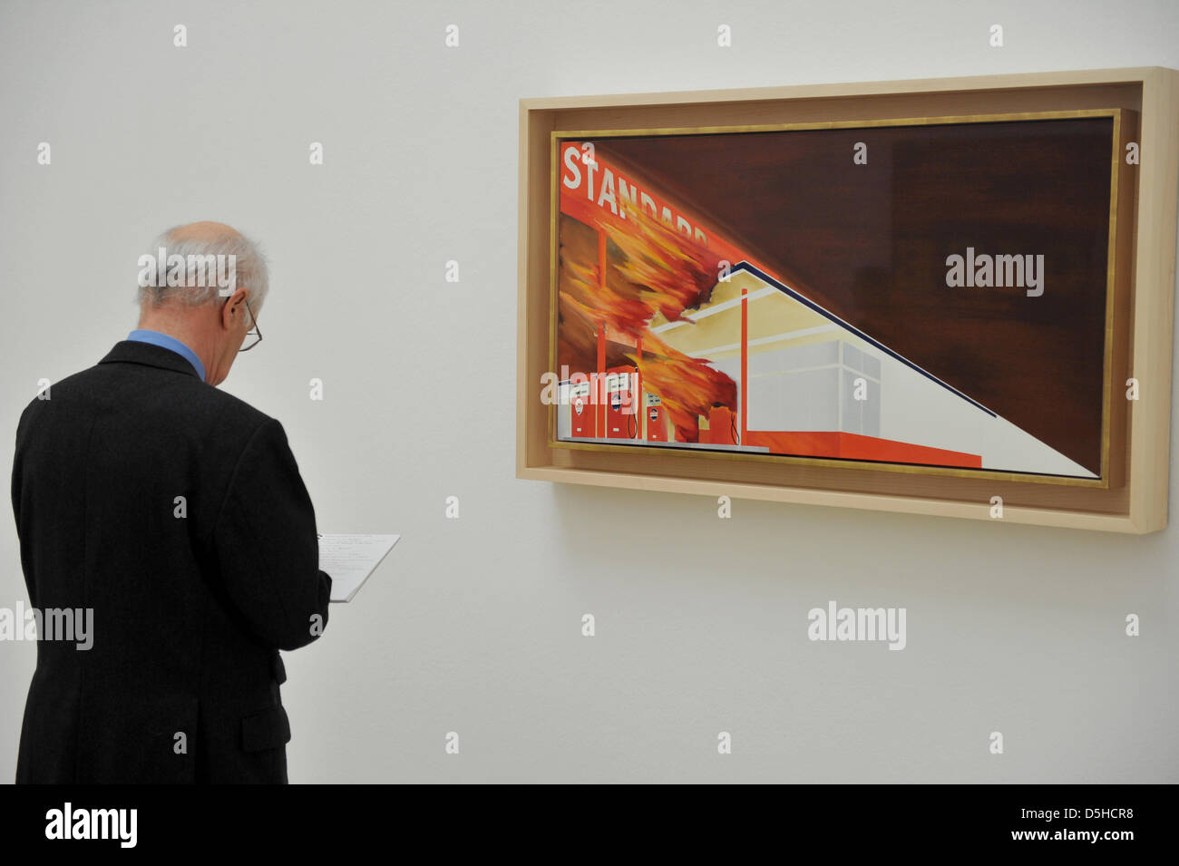 Ein Mann blickt auf ein Bild des Künstlers Ed Ruscha mit dem Titel "brennendes Gas Station" (1965/1966) in der Ausstellung "Ed Ruscha: 50 Years of Painting" im "Haus der Kunst" (Haus der Künste) in München, Deutschland, 11. Februar 2010. Die Ausstellung ist vom 12. Februar bis 2. Mai 2010 geöffnet. Foto: FELIX HOERHAGER Stockfoto