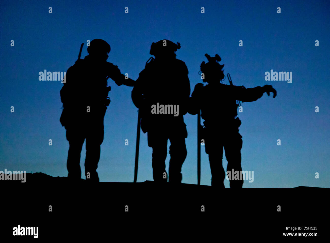 Silhouette gegen Dämmerung, die uns Marine Special Operations Team Mitglieder mit Sicherheit während eines Bauprojektes für eine afghanische Polizei-Checkpoint 30. März 2013 in der Provinz Helmand, Afghanistan zu unterstützen. Stockfoto