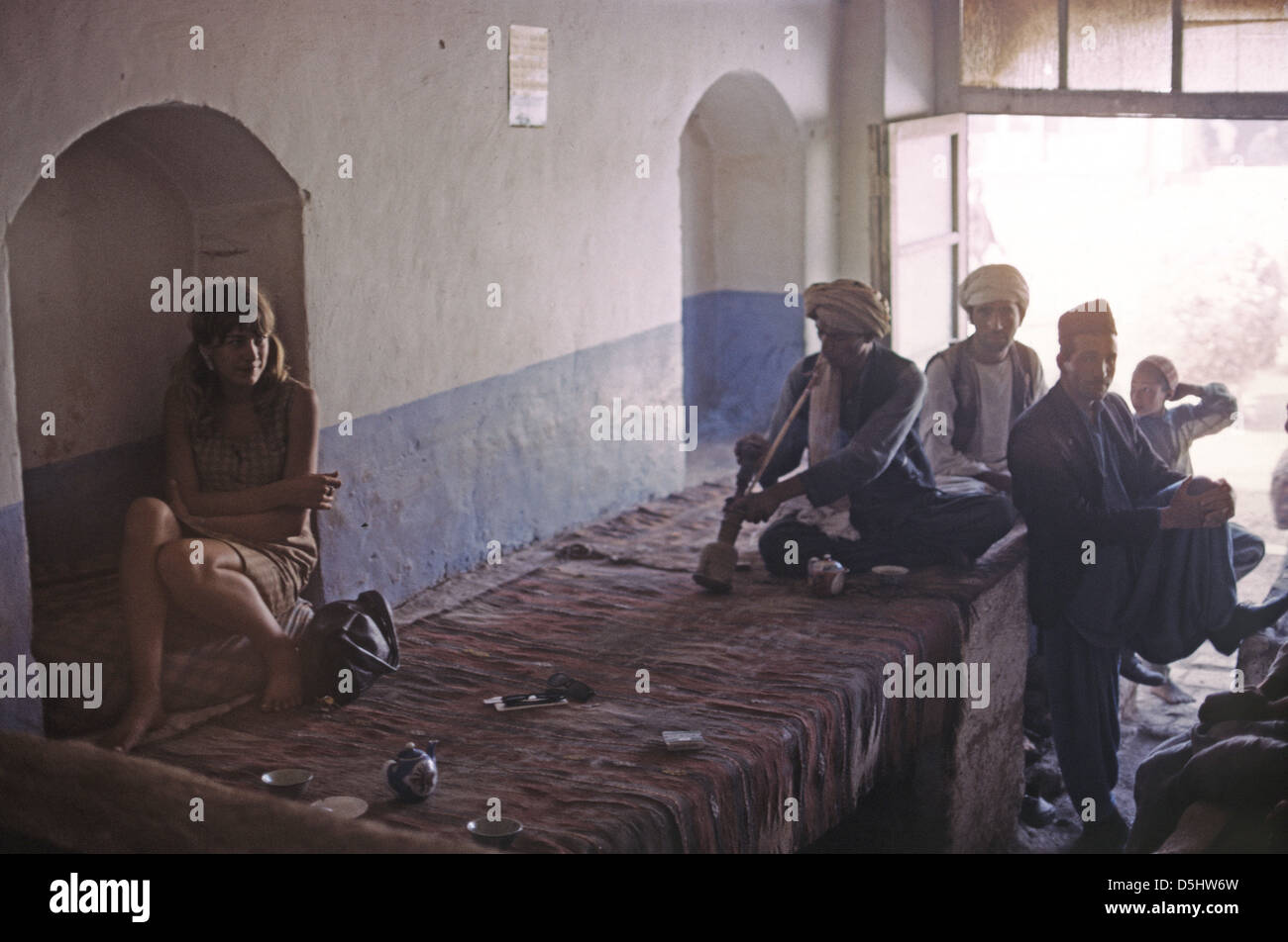 Junge Touristen Frau in den 1960ern Rauchen in einem Café in Afghanistann Aufruf der Mandonlin Herat Cafe umgeben von muslimischen Männern Stockfoto