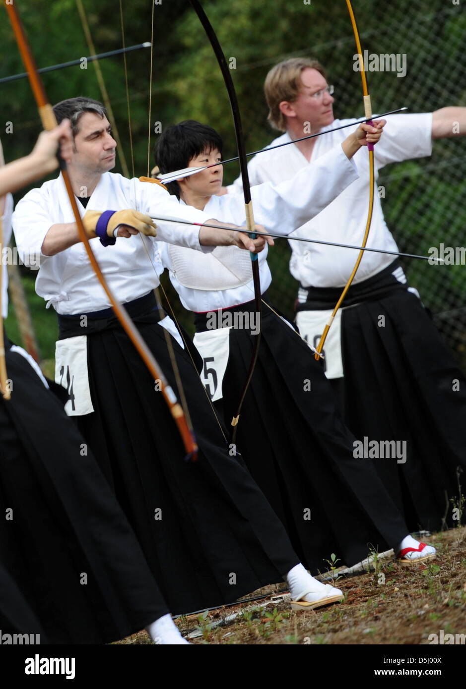 Teilnehmer des "Offenen Frankfurt" Bogen tragen traditionelle Kleidung - langen, schwarzen Culottes, weißes Hemd und schwarze Gürtel - während der japanischen Bogenschießens Veranstaltung in Frankfurt Main, Deutschland, 1. September 2012. Pfeile werden aus den zwei Meter großen Holzbogen bei einer 36 Zentimeter großen Scheibe 28 Meter geschossen. Foto: Roland Holschneider Stockfoto