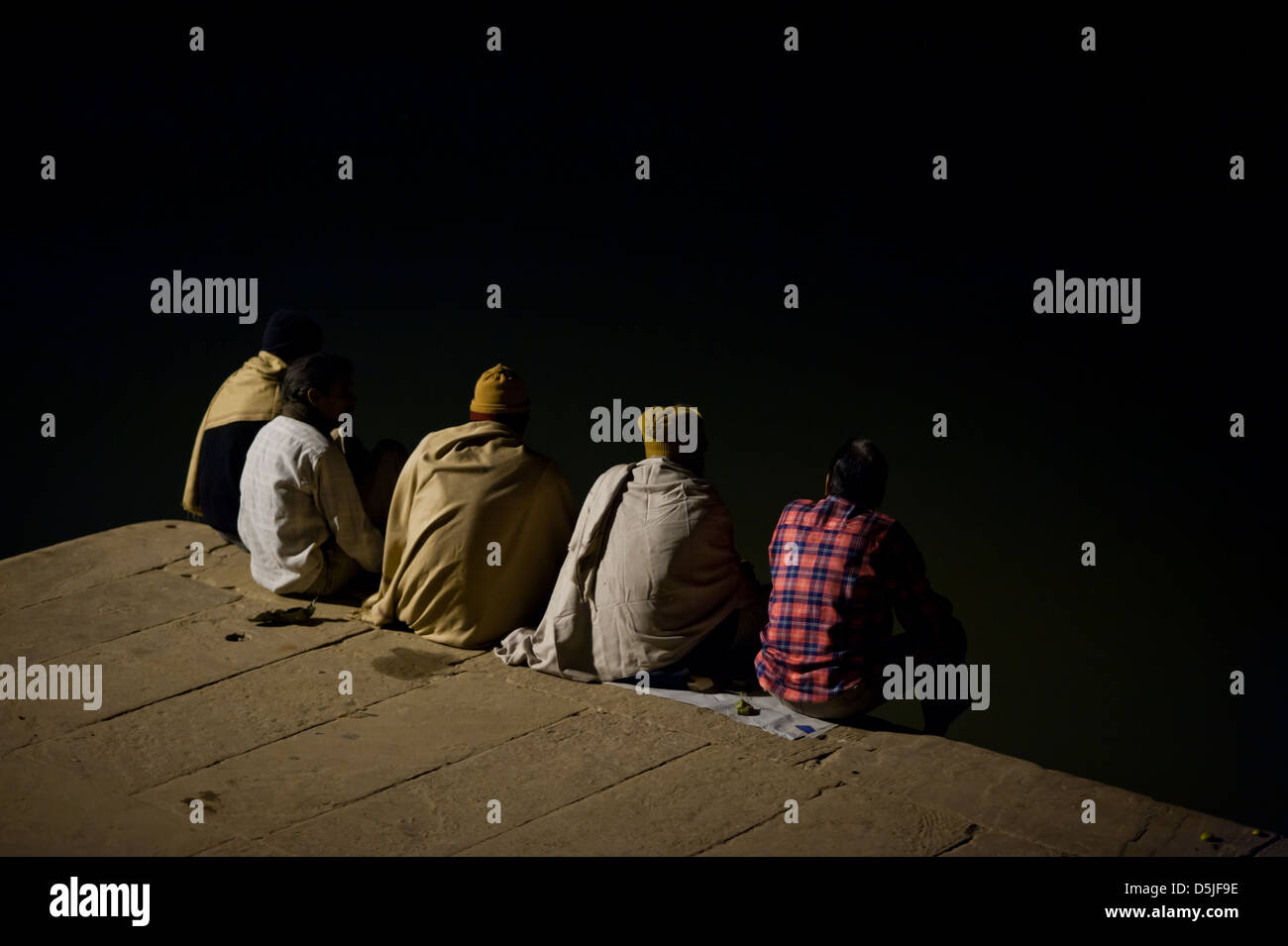 5 anonyme Freunde sitzen und sprechen, indem der Fluss Ganges. Indien Stockfoto