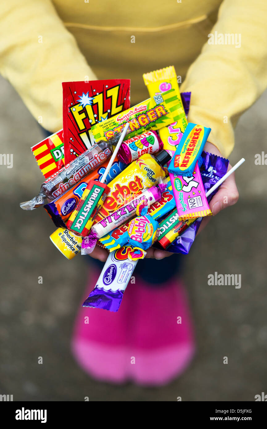 Mädchen-Hände halten verschiedene Kinder Retro-Süßigkeiten und Bonbons Stockfoto