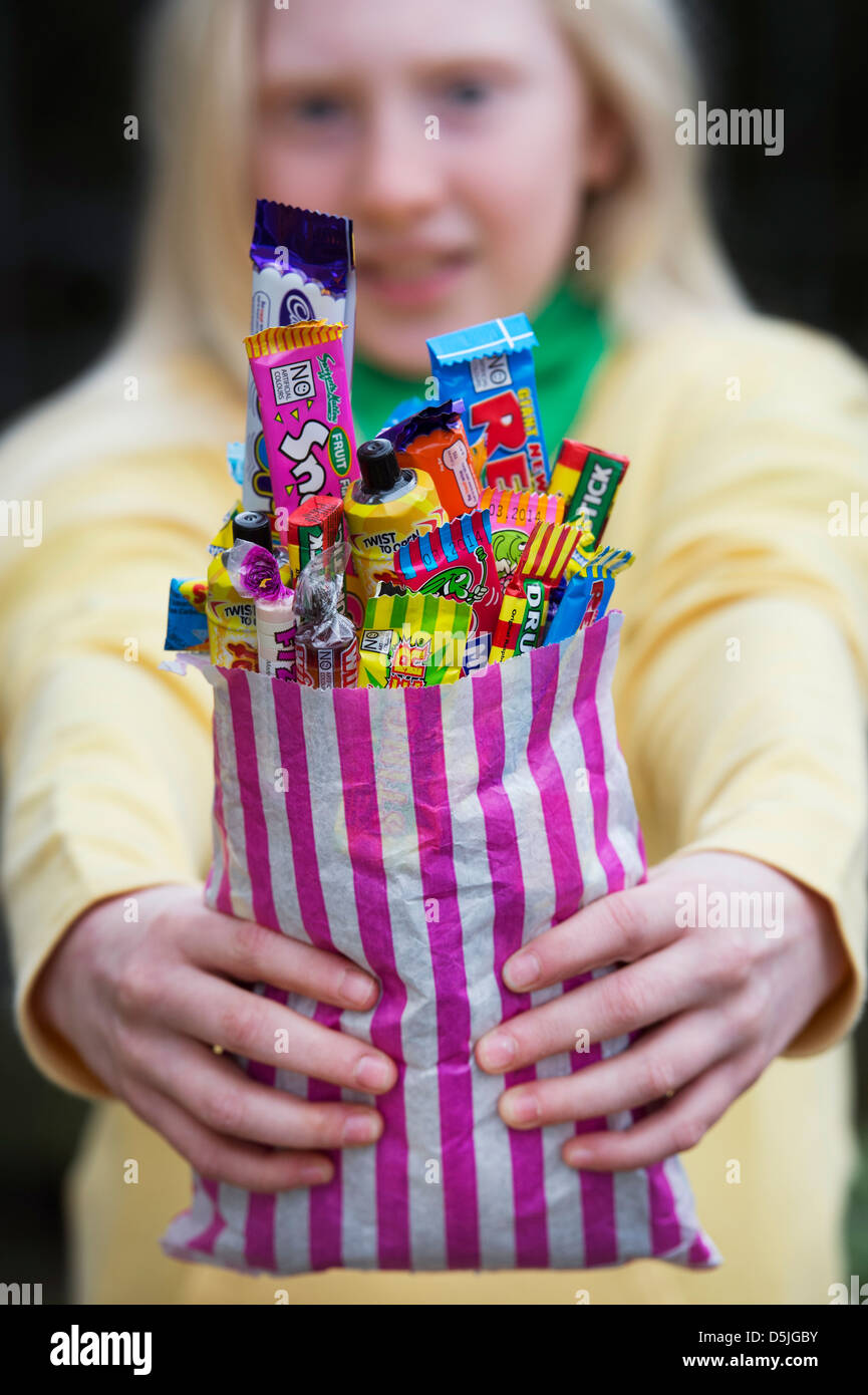 Mädchen hält einen Beutel mit sortierten Kinder Retro-Süßigkeiten und Bonbons Stockfoto
