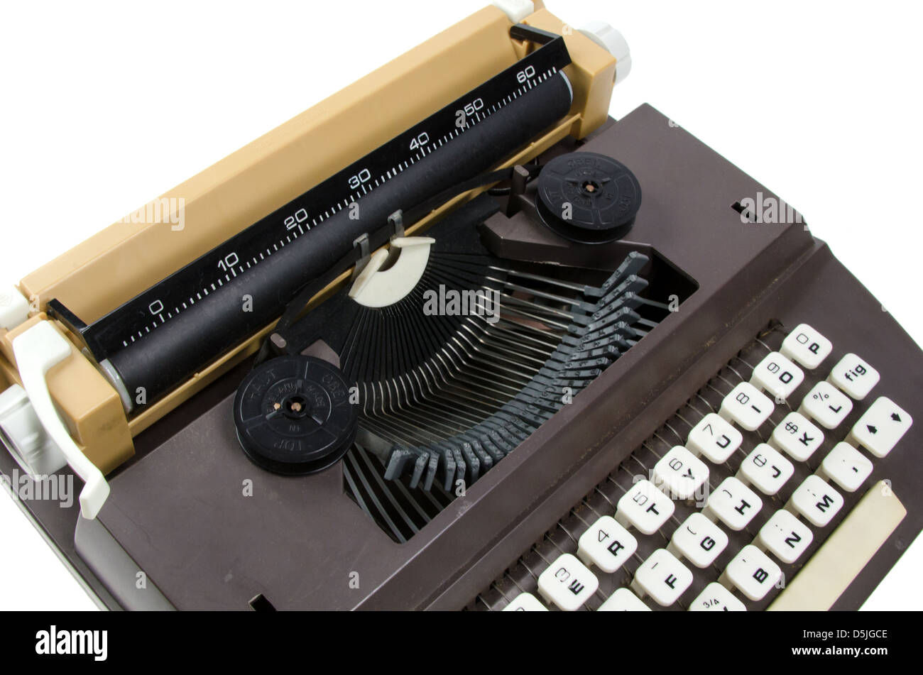 Detail einer braunen und beigen Plastikspielzeug Schreibmaschine auf weißem Hintergrund. Stockfoto