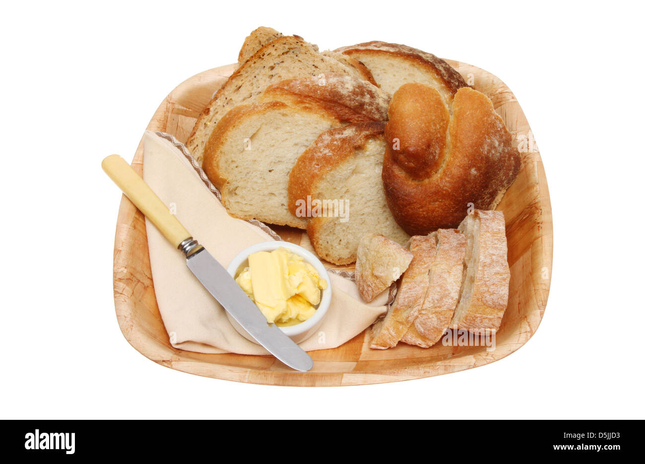 Auswahl an Brot mit Butter, ein Messer und eine Serviette in einer Holzschale isoliert gegen weiß Stockfoto