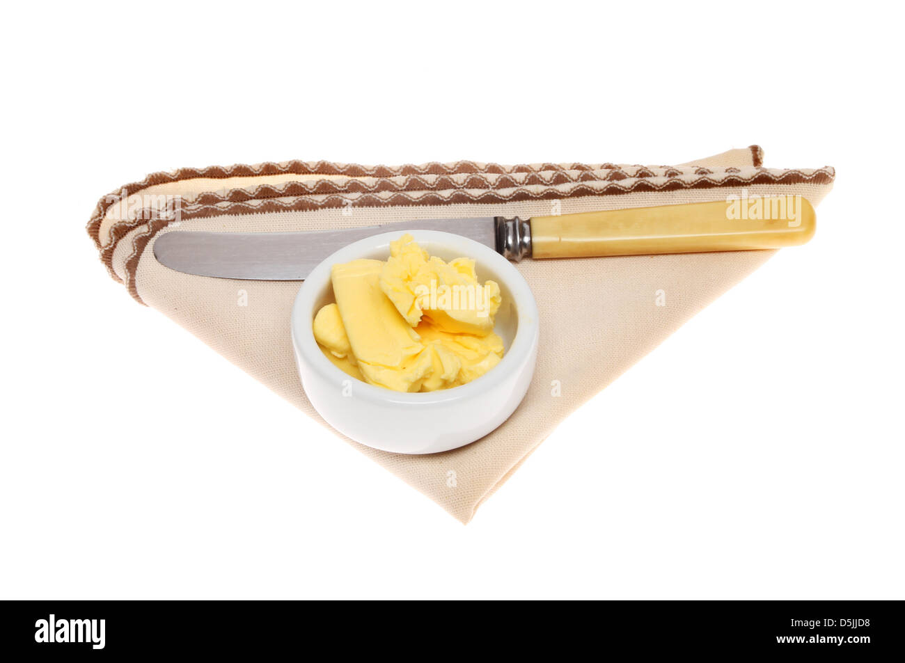 Butter in einem Töpfchen mit einem Messer auf eine Serviette isoliert gegen weiß Stockfoto