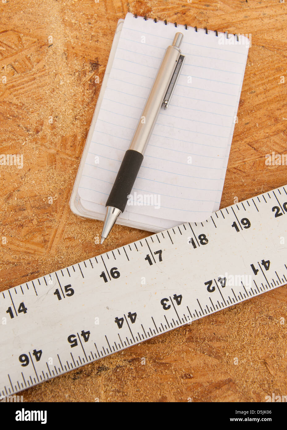 Geradlinig, Notizblock und Stift auf Sperrholz, Konzept der Planung für eine Struktur oder andere Holzarbeiten; unfertige Erzeugnisse Stockfoto