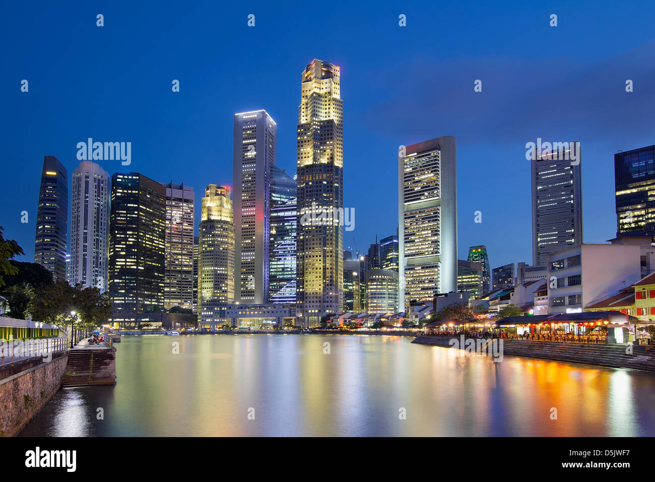 Skyline von Singapur Central Business District (CBD) von Boat Quay am Singapore River zur blauen Stunde Stockfoto