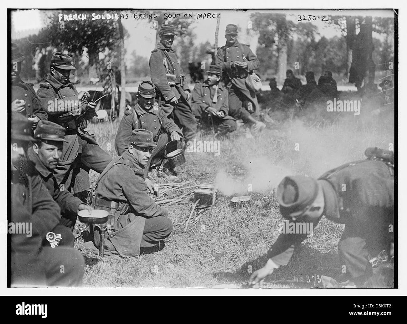 Während des Ersten Weltkriegs werden französische Soldaten auf einem marsch beim Essen von Suppe gezeigt. Dieses Bild zeigt die Schwierigkeiten, denen die Soldaten gegenüberstehen, und verwendet Mess-Kits für Mahlzeiten auf dem Feld. Stockfoto