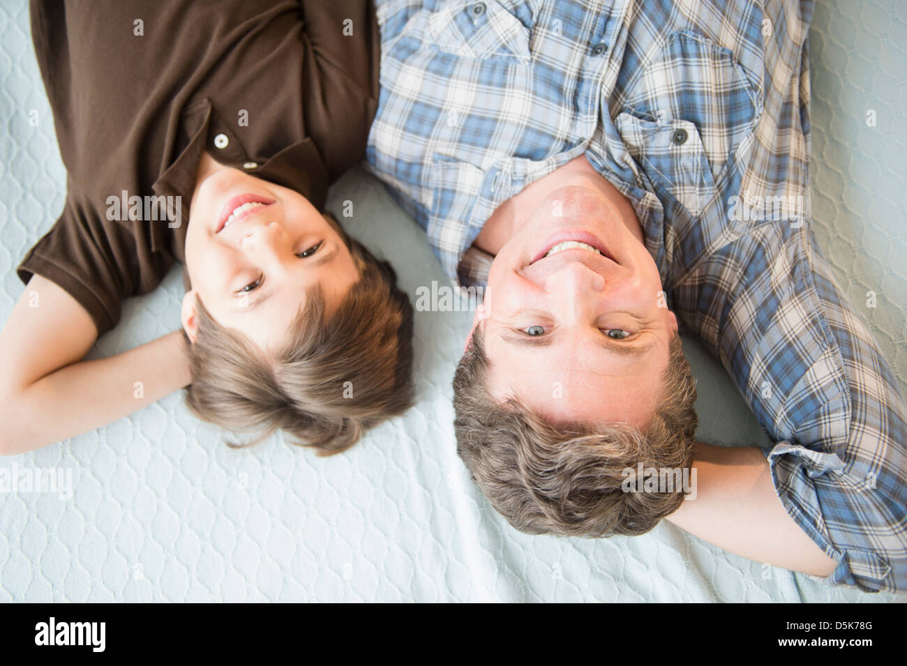 Vater und Sohn (8-9) auf Bett liegend Stockfoto