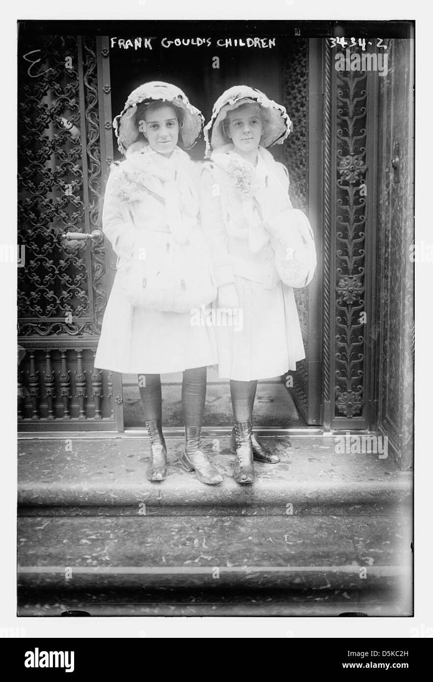 Ein 1915 Foto von Frank Goulds Kindern im Freien, die vor einer Tür stehen, mit Oster-Haube und -Stiefeln. Es fängt den Moment eines traditionellen Sonntagsausflugs ein. Stockfoto