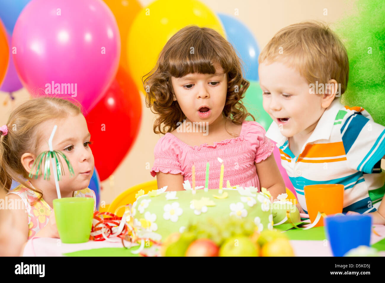 Kinder Geburtstagsparty feiern und Ausblasen der Kerzen auf Kuchen Stockfoto