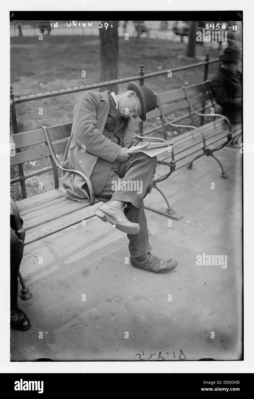 Dieses Foto zeigt einen Mann, der auf einer Parkbank am Union Square, New York City, ruht und einen Moment des Alltags im Park festnimmt. Stockfoto
