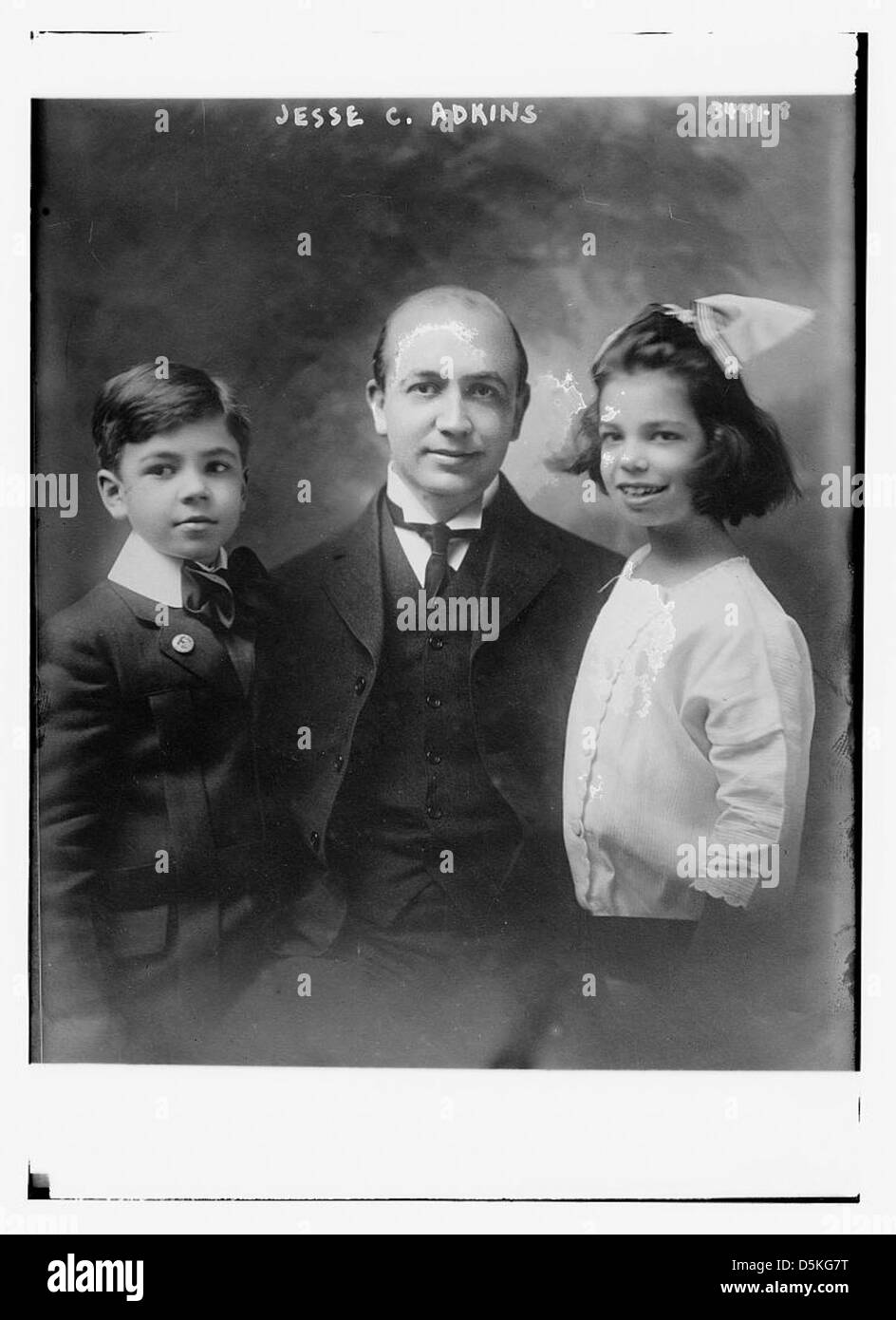 Ein Foto von Jesse C. Adkins, das ihn mit Kindern zeigt, einschließlich eines Jungen und eines Mädchens, wahrscheinlich in einem professionellen oder gemeinschaftlichen Umfeld. Stockfoto
