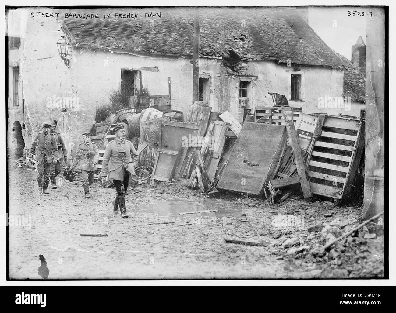 Ein Foto, das eine Straßenbarrikade in French Town während eines historischen Konflikts darstellt. Das Bild erfasst die Struktur und Umgebung der Barrikade in einer städtischen Umgebung. Stockfoto