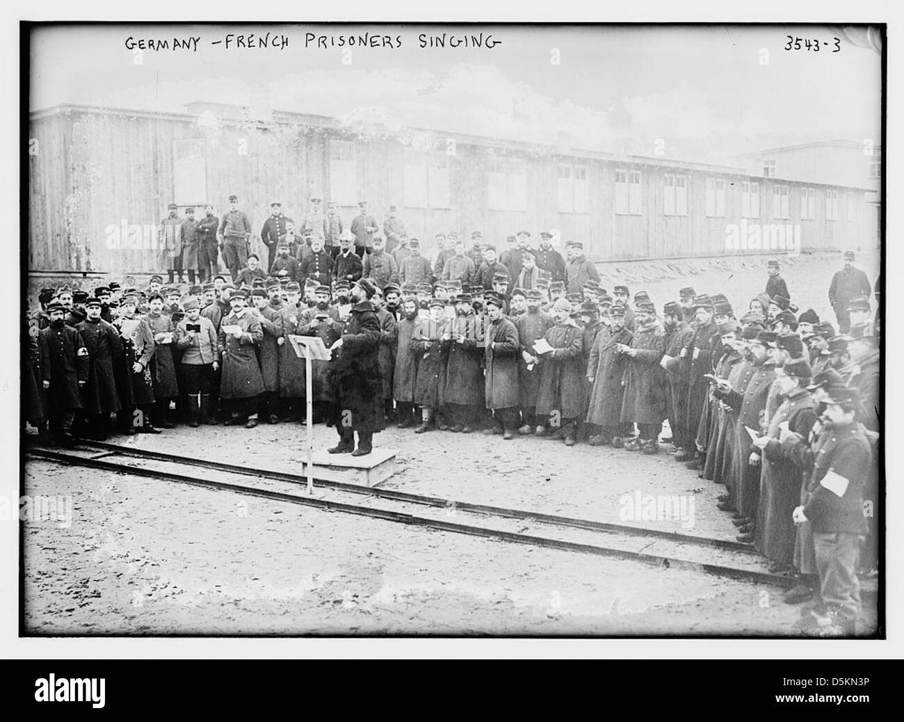 Ein Foto aus dem Ersten Weltkrieg, das französische Kriegsgefangene in einem deutschen Gefangenenlager singt. Das Bild fängt einen Moment des kulturellen Ausdrucks während der Gefangenschaft ein. Stockfoto