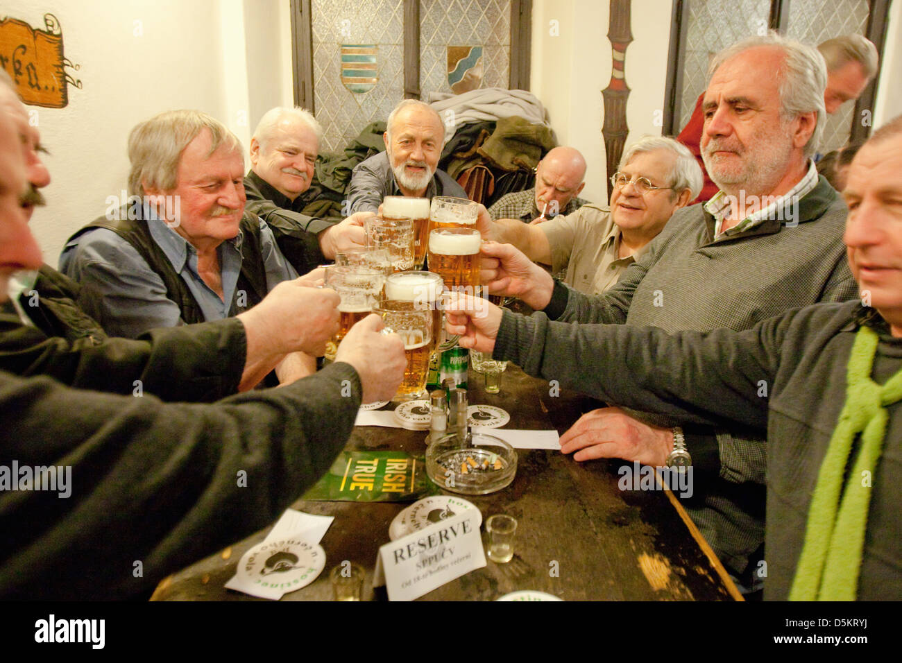 Prag - Freunde in einem traditionellen tschechischen Kneipe Toasten mit Bier. Stockfoto