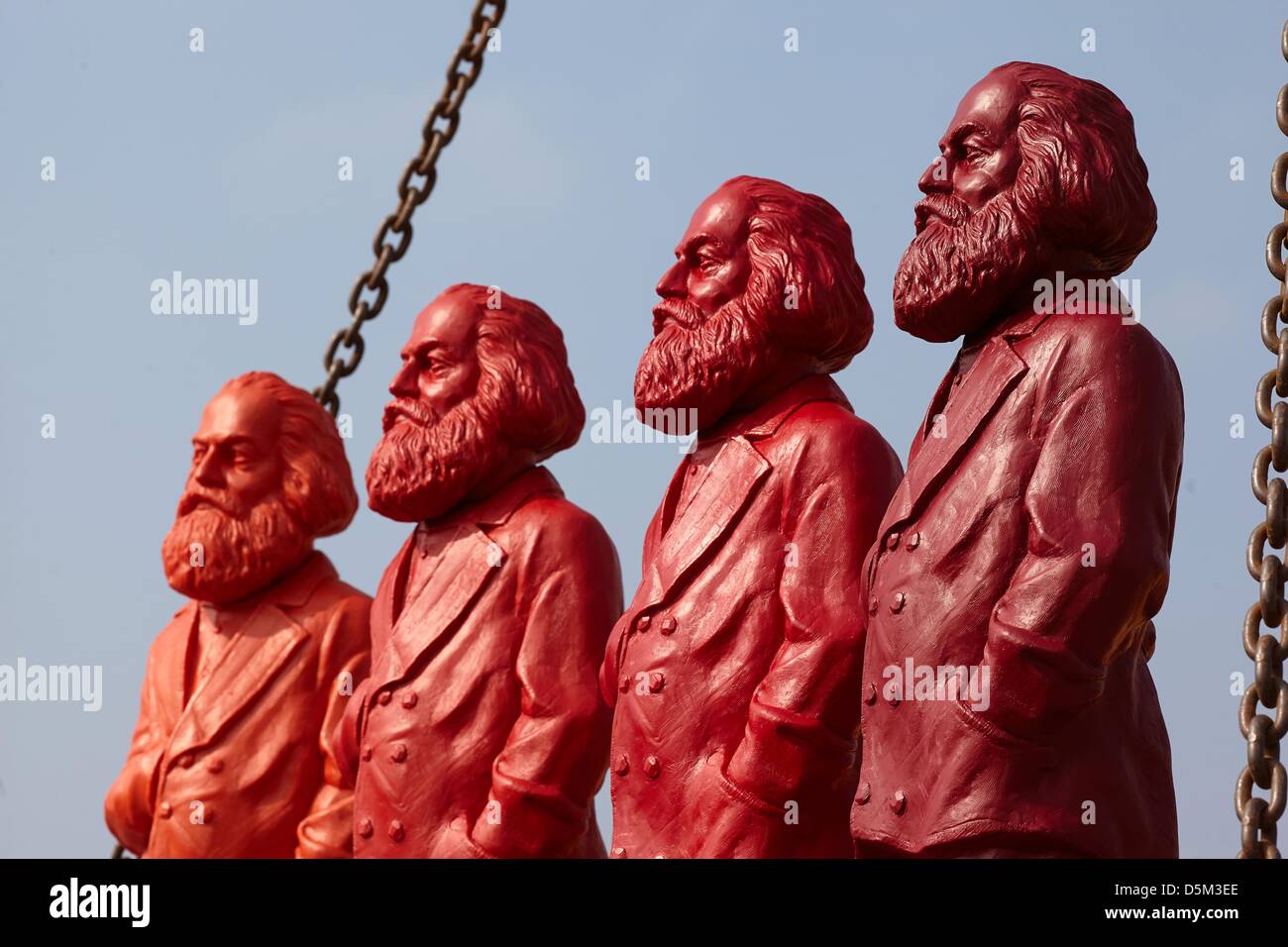 Vier verschiedene farbigen Karl Marx Figuren des Künstlers Ottmar Hoerl  werden vorgestellt, auf dem Gelände einer Kranfirma in Trier, Deutschland,  4. April 2013. Die Zahlen werden auf dem Display von 05 bis