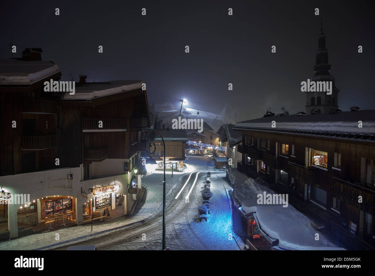 La Clusaz Stadt in den französischen Alpen in der Nacht mit Blick auf den Hauptplatz und Pisten. Stockfoto