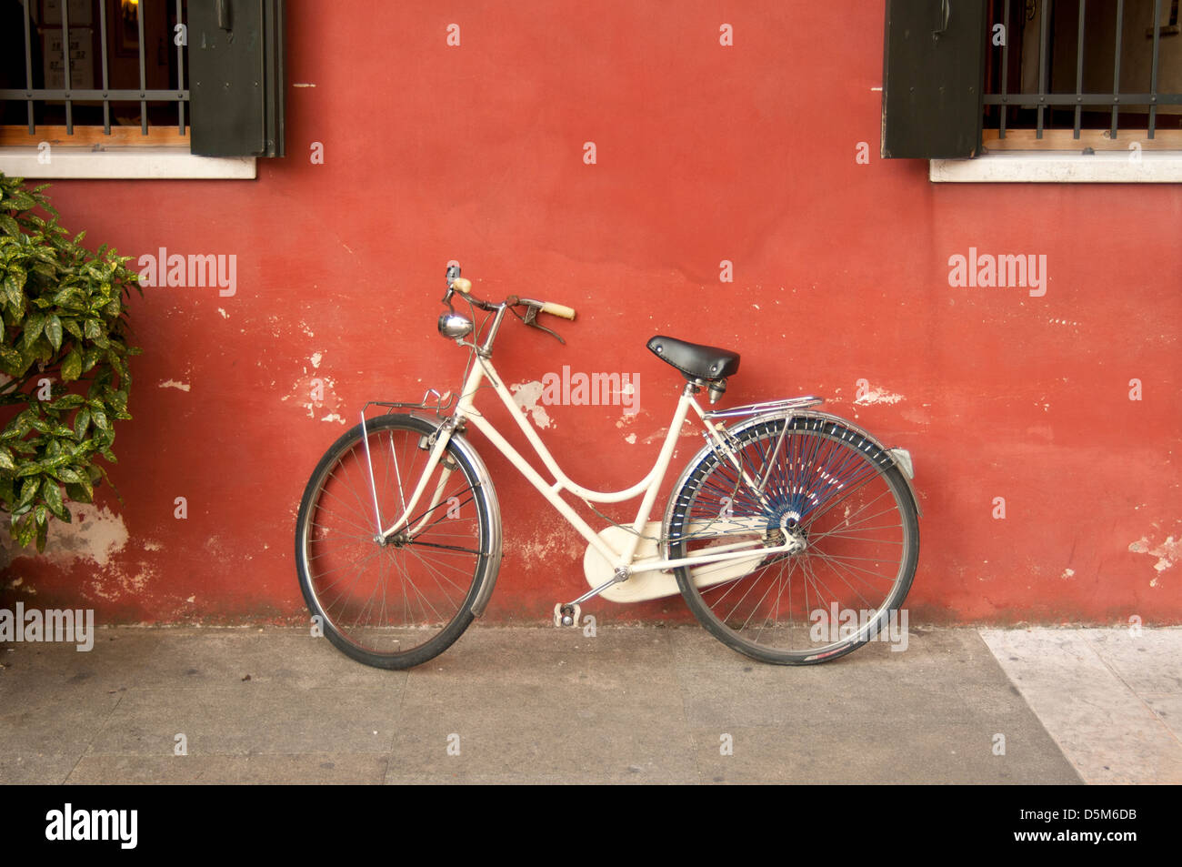Fahrrad lehnte sich gegen farbige Wand, Motta di Livenza, Venetien, Italien Stockfoto