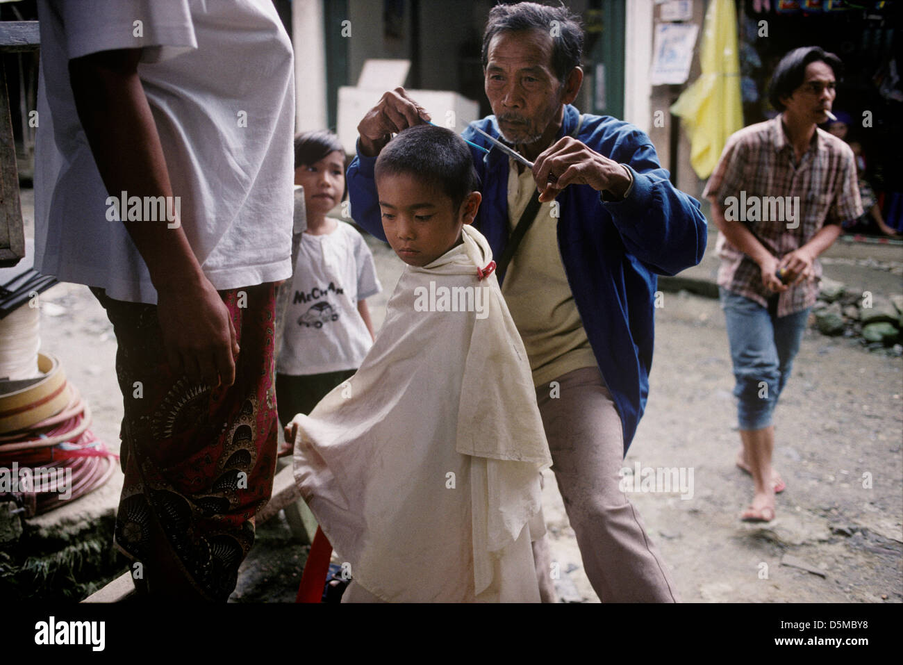 Straße Friseur einen Haarschnitt zu geben, wie Kinder aussehen auf. Mount Apo, Mindanao. Die Philippinen. Stockfoto