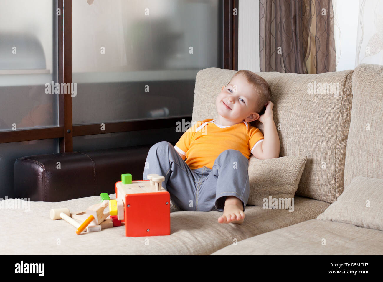 entzückende junge spielt mit Spielzeug zu Hause Holzbau Stockfoto