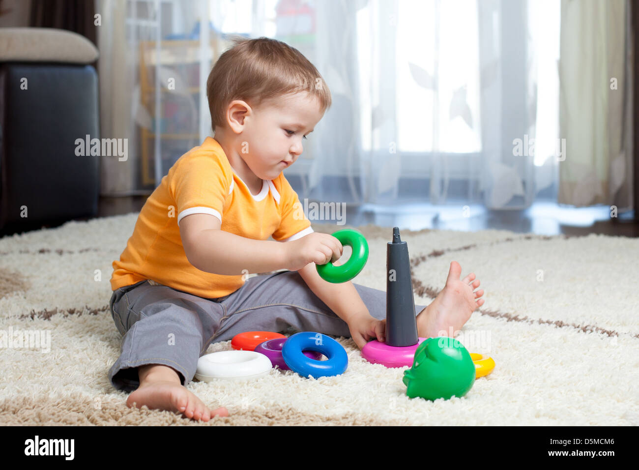 Kind Junge spielt mit Spielzeug zu Hause Stockfoto