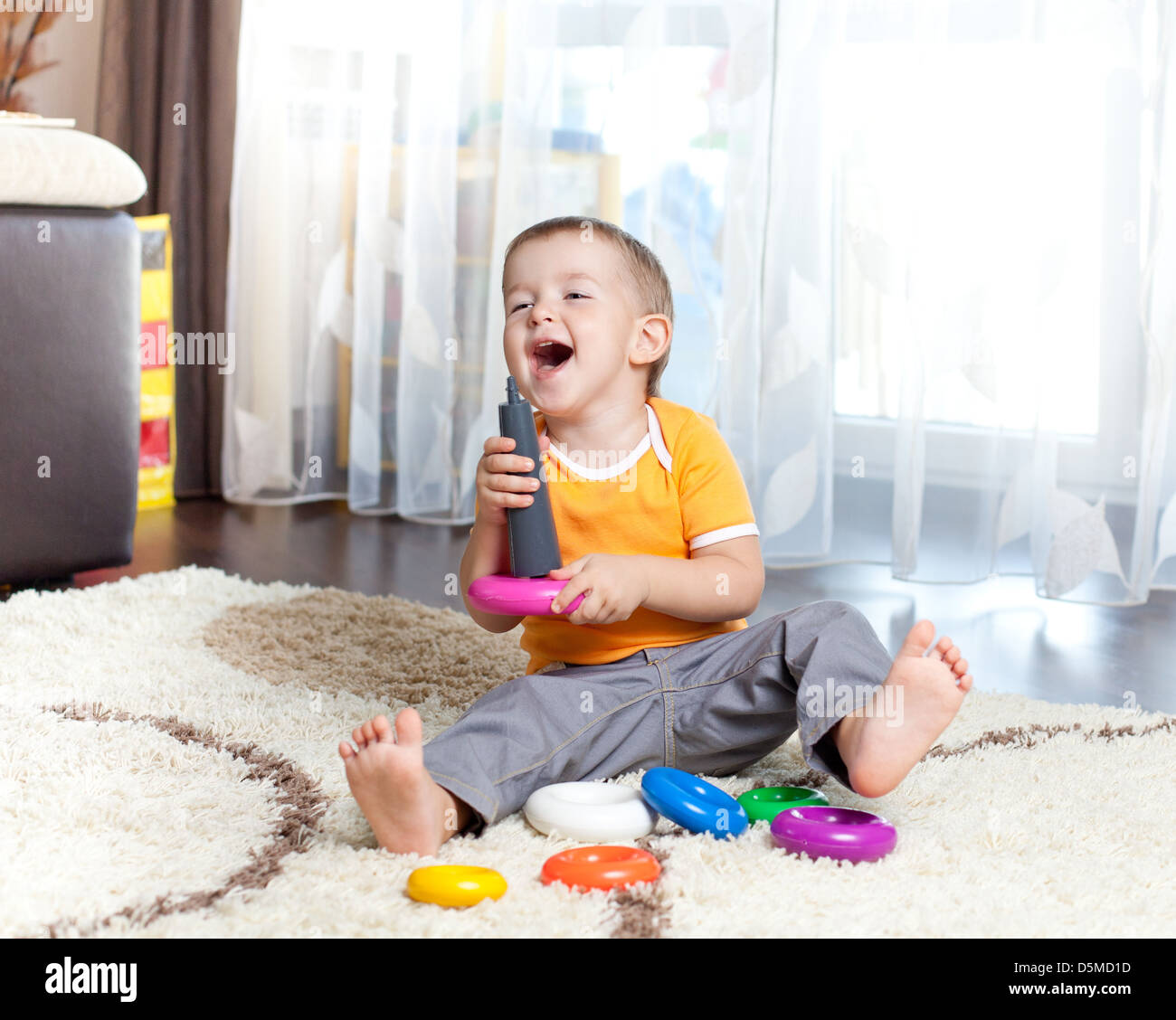 lustiges Kind spielt mit Spielzeug indoor Stockfoto