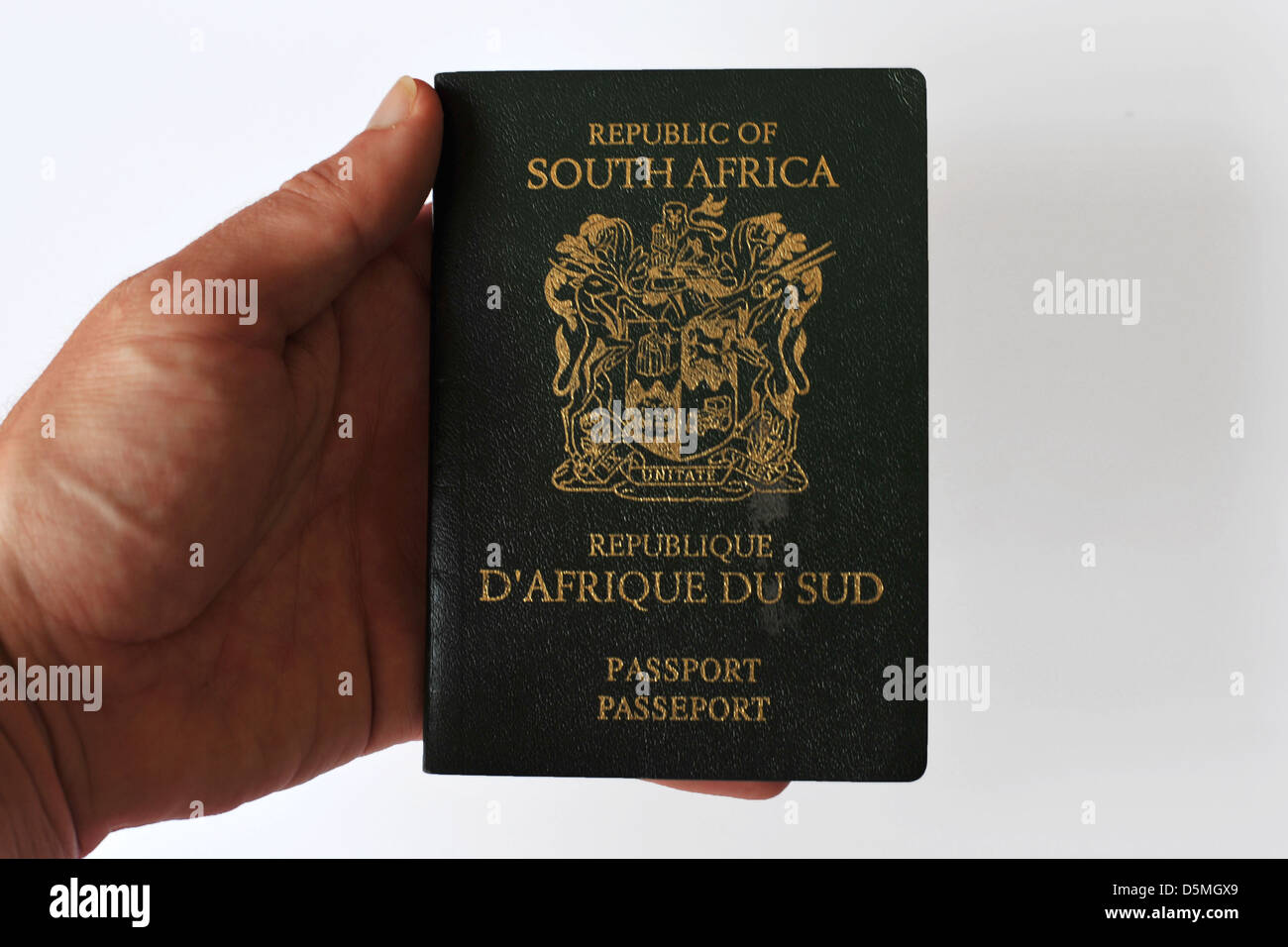 Eine weiße Hand berühren das alte Design des südafrikanischen Reisepasses im Studio. Stockfoto