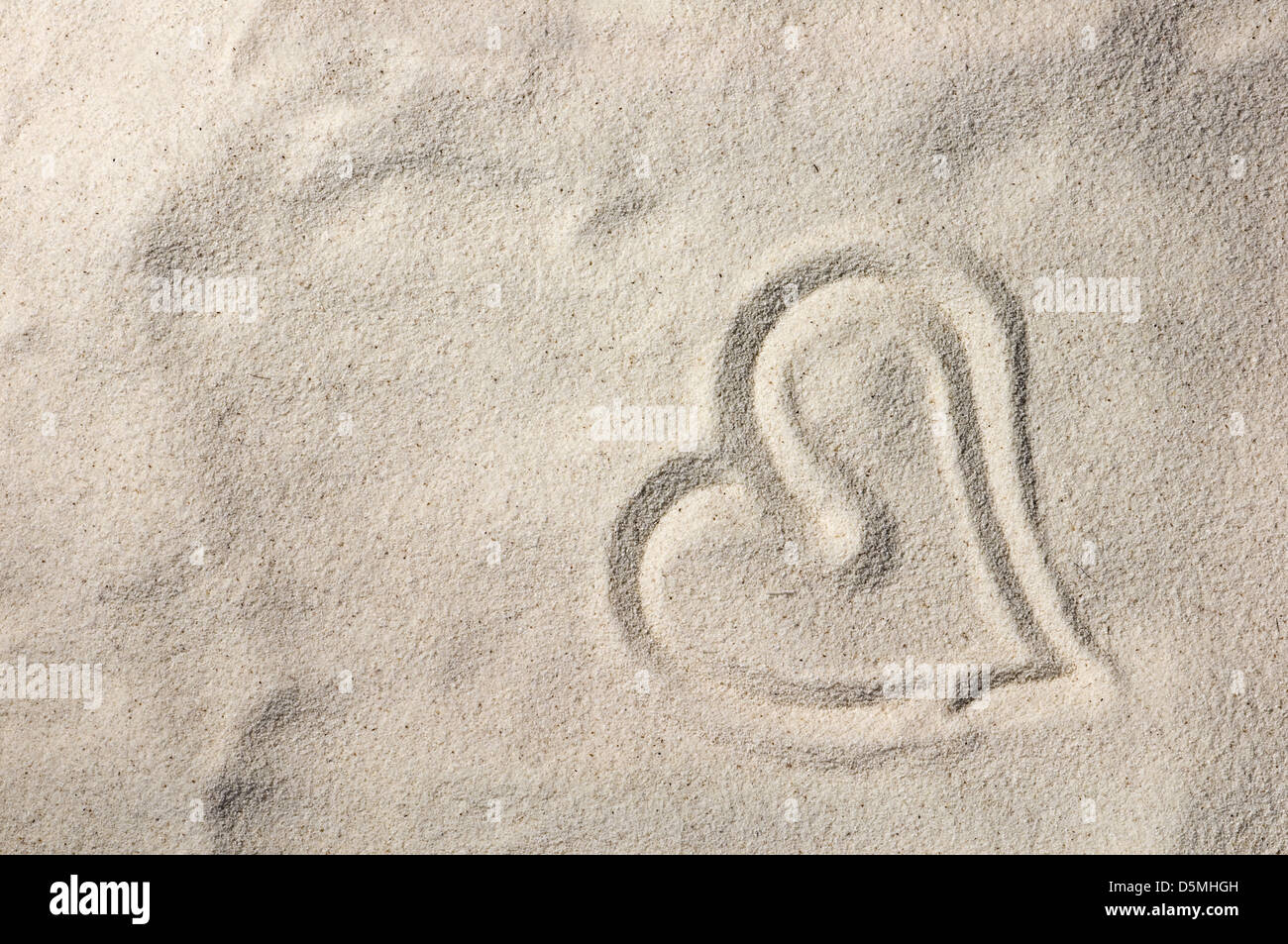 Herz auf Sand am Meeresstrand Stockfoto