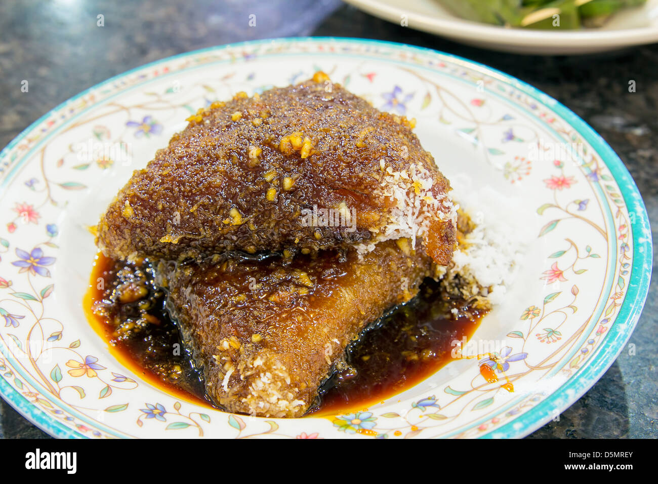 Malaiische Kueh Lopes mit Gula Melaka Zuckersirup und Kokosraspeln Dessert Stockfoto