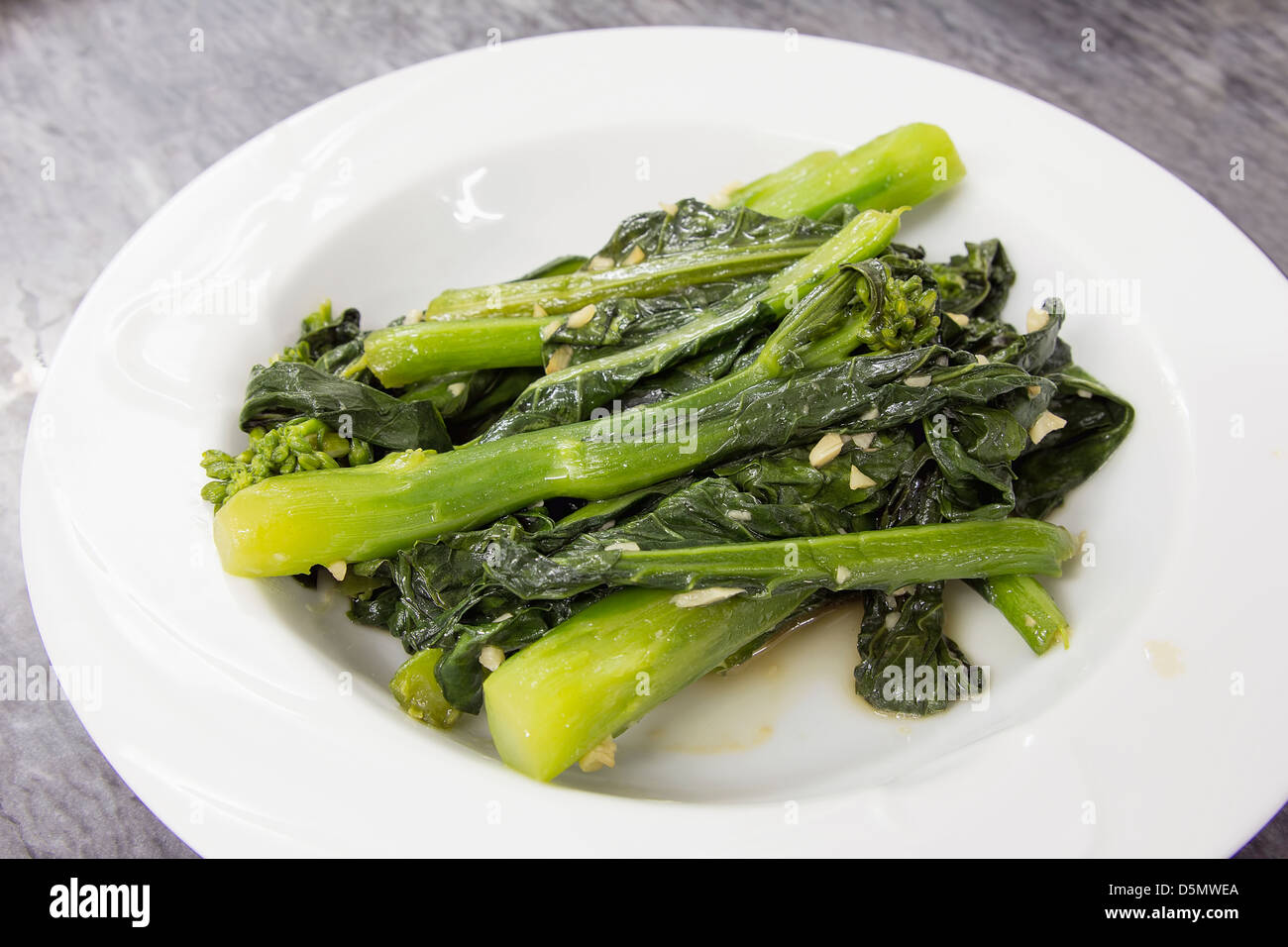 Chinesische Kai Lan grünes Gemüse mit Knoblauch und Öl gedünstet Stockfoto