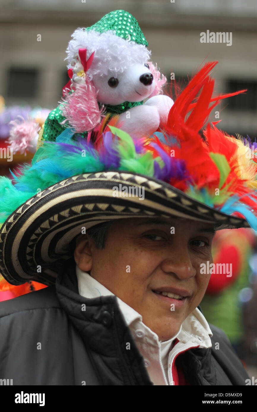 Ein Mann trägt einen Hut verziert mit Federn und ein Stofftier, Teilnahme an New York Citys Easter Parade Stockfoto