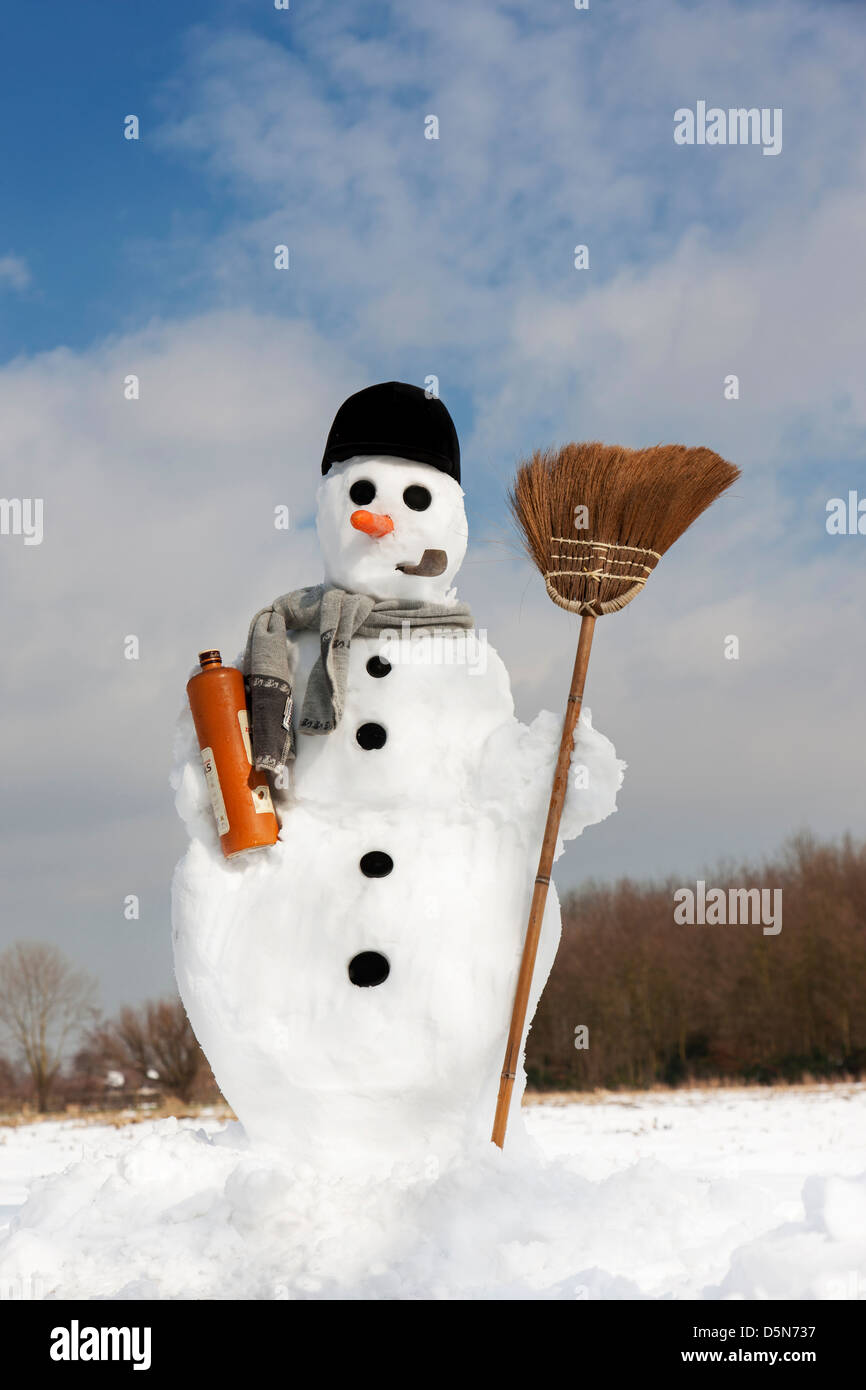 Glücklich Schneemann mit Karotten-Nase, Mütze, Rohr, Schal und Besen im Schnee im Winter eingerichtet Stockfoto