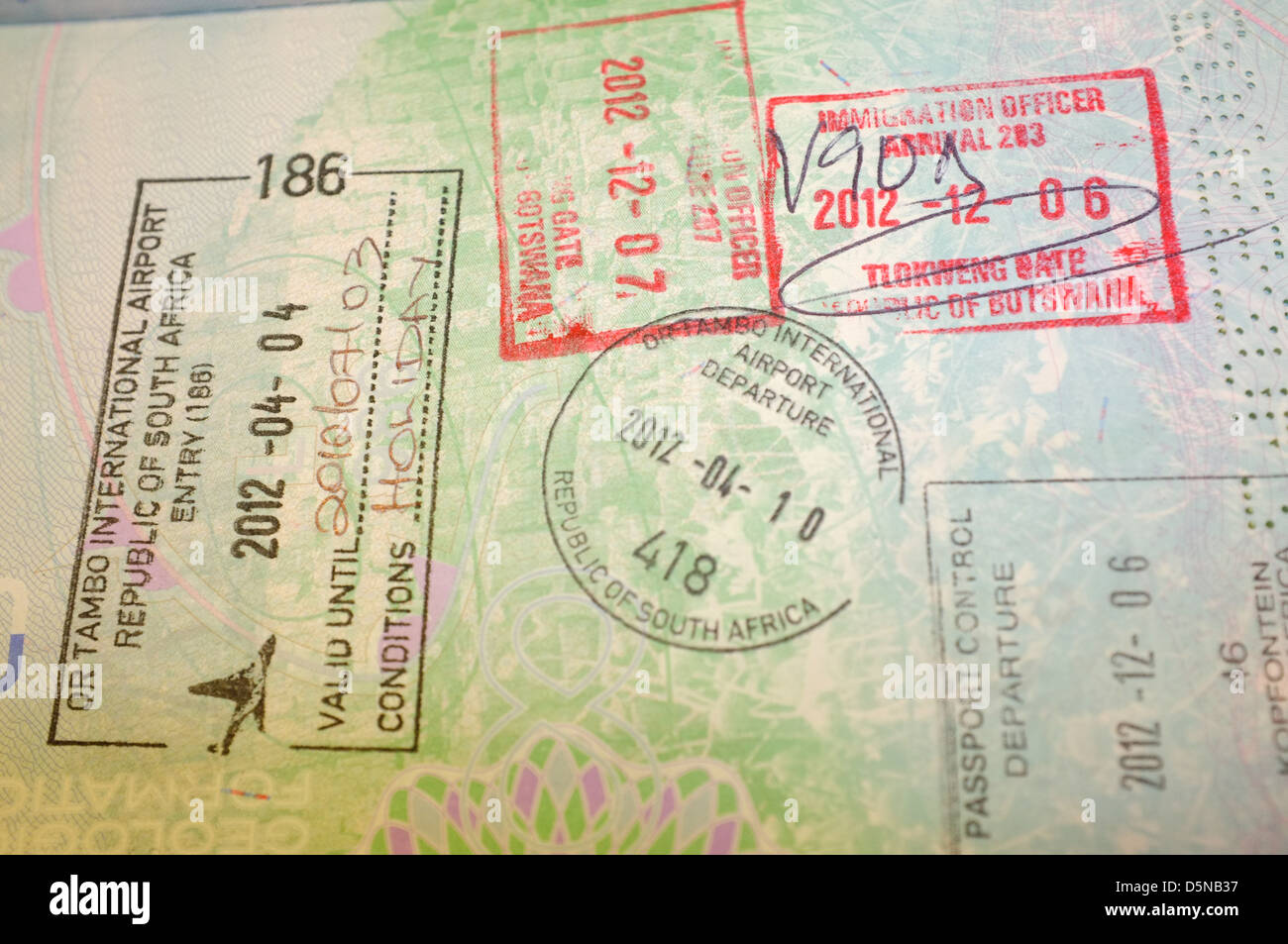 Eine Visaseite in einem Reisepass Visum Briefmarken aus vergangenen Reisen bedeckt. Stockfoto
